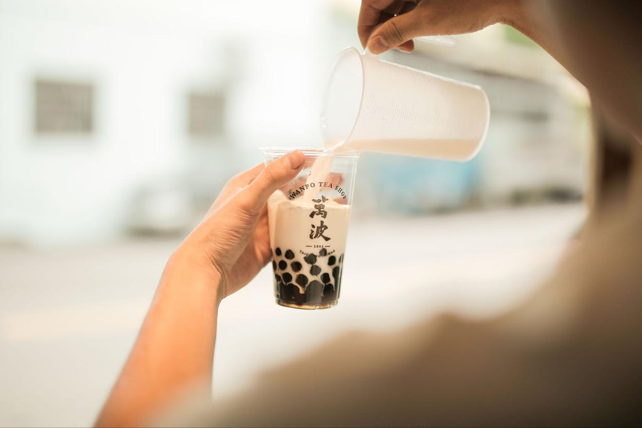milk being poured into a delicious-looking boba milk tea